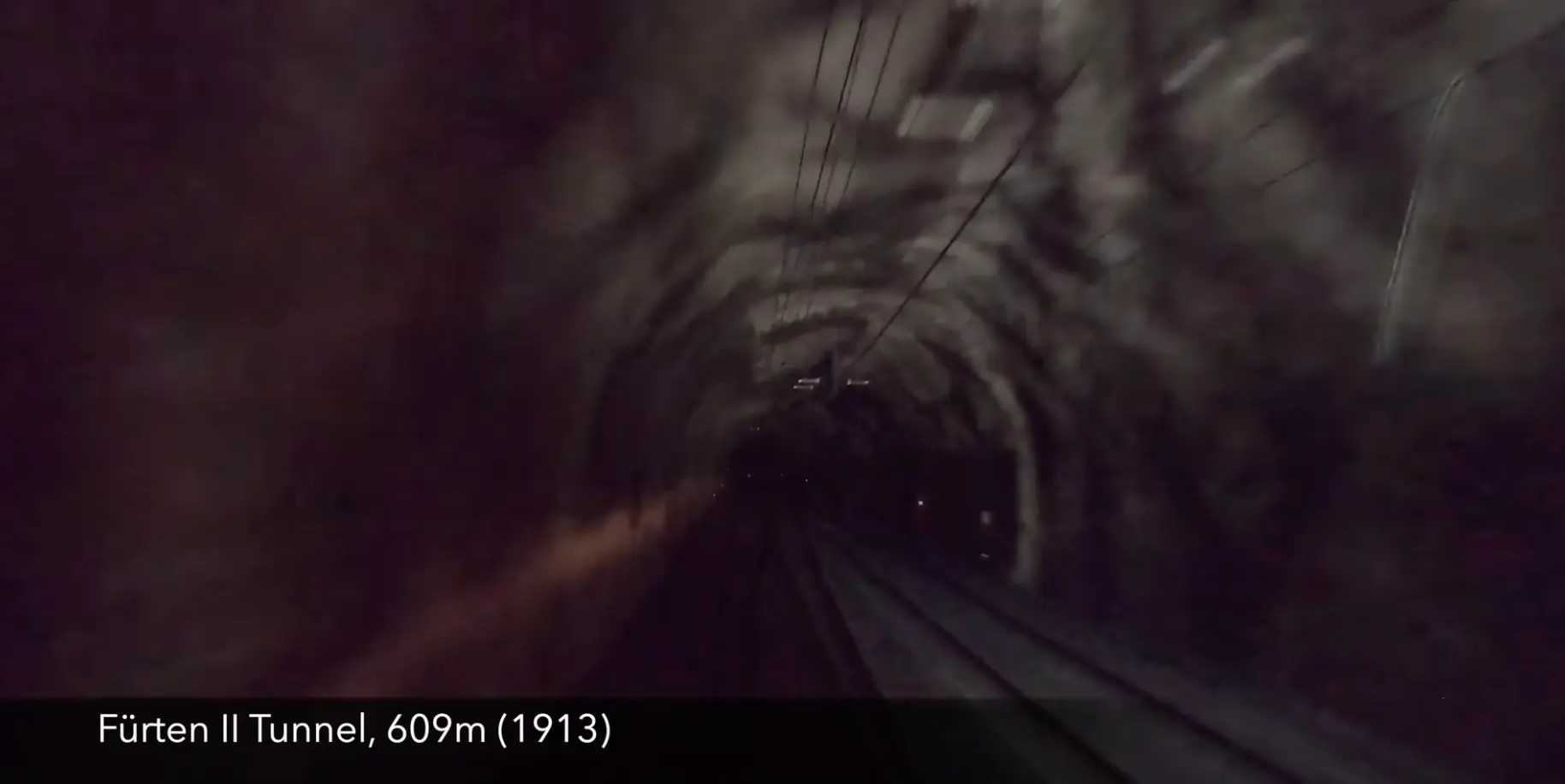 Screenshot from train video  showing a tunnel. A label on screen says 'Fürten II Tunnel, 609 m (1913)'